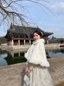 著公主韓服於慶會樓前拍照